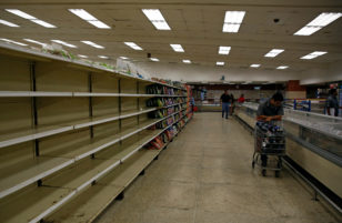 People buy food and other staple goods inside a supermarket in Caracas