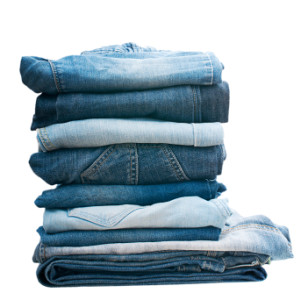 Pile of blue jeans isolated on white.