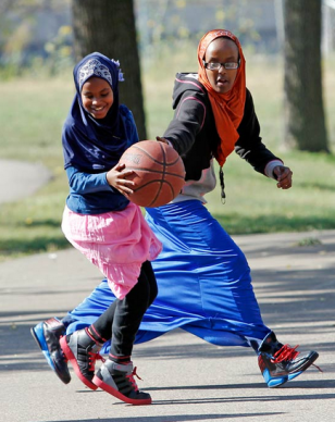 While many Somalis have adapted slowly to American life, a sense of alienation persists for some, giving an opening for recruiters from Al-Shabab and Islamic State. In this September 27, 2013, file photo, young women play basketball before the start of a rally by the Minneapolis Somali community against terrorism. (Reuters)