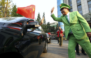 In this photo taken Wednesday, Oct. 10, 2012, Chinese billionaire and philanthropist Chen Guangbiao at right gestures to a driver of one of the new Chinese car he offered to owners of Japanese cars damaged during anti-Japan protests in Nanjing in eastern China's Jiangsu province. Chen offered replacement cars to 43 of his microblog followers who had their cars damaged by demonstrators. (AP Photo) 