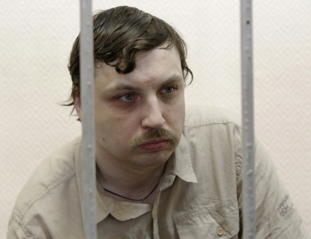 Mikhail Kosenko sits inside a defendants' cage during a court hearing in Moscow May 29, 2013. A Russian court on Tuesday ordered Kosenko, a critic of President Vladimir Putin confined to a psychiatric ward indefinitely over clashes with police at a protest, a ruling likened by rights activists to abuses of psychiatry during the Soviet era to jail dissidents. Kosenko, who had undergone outpatient psychiatric treatment before his arrest, was among more than two dozen accused of rioting at a protest in Moscow on May 6, 2012, the eve of Putin's inauguration to a new six-year term. Picture taken May 29, 2013. REUTERS/Maxim Shemetov
