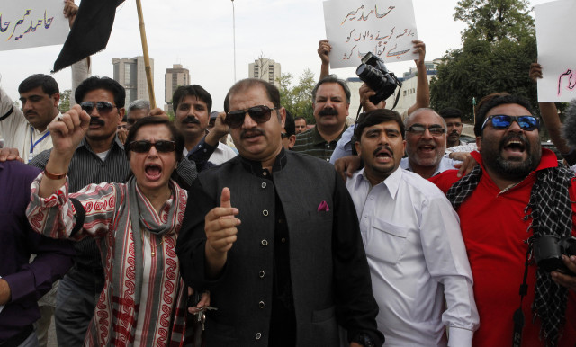 Pakistani journalists chant slogans during a protest, called by PFUJ, against the attack on television anchorperson Hamid Mir, outside the press club in Islamabad