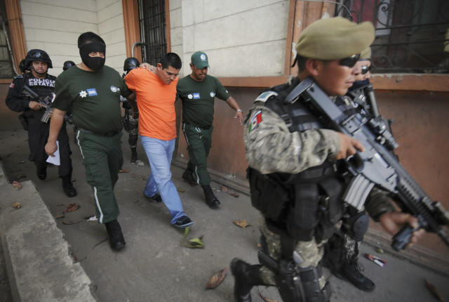 State police officers escort Clemente Martinez, who is arrested in connection with the murder of journalist Moises Sanchez, out of a court house in Veracruz January 26, 2015. Mexican prosecutors are investigating a small-town mayor in connection with the murder of a journalist in the Mexican Gulf coast state of Veracruz, whose brutalized body was found over the weekend, a state official said on Monday. A local drug gang member, confessed to kidnapping and killing journalist Sanchez, in league with five accomplices, Veracruz state prosecutor Luis Bravo said. The accused said he was given orders by a local police official and the bodyguard of Medellin de Bravo Mayor Omar Cruz. REUTERS/Yahir Ceballos 