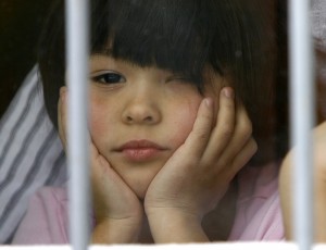 An orphan child looks out from a window at an orphanage in the southern Russian city of Rostov-on-Don