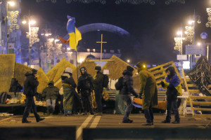 Behind wooden barricades, anti-government protesters wonder if the police will launch another night attack. Photo: AP/Sergei Grits