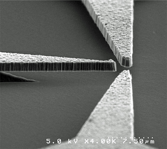 Scanned Electron Microscope image of a triode made from nanodiamond thin film that shows how the diamond components are cantilevered over a silicon dioxide substrate.  (Photo: Davidson Laboratory, Vanderbilt University)