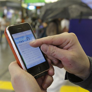 In this June 14, 2010 photo, Daisuke Tsuda tweets with his mobile phone at a station in Tokyo. "Japan is enjoying the richest and most varied form of Twitter usage as communication tool," says Tsuda, 36, a writer with more than 65,000 "followers" for his tweets. "It's playing out as a rediscovery of the Internet." (AP Photo/Koji Sasahara)