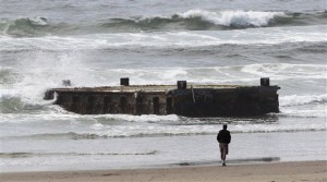 A man looks at a 70-foot-long dock with Japanese lettering that washed ashore in Newport Oregon more than a year after a tsunami devastated Japan (Photo: AP Photo/Rick Bowmer, File)