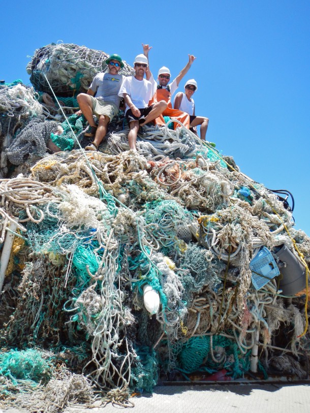 Participants of marine debris removal activities sit atop a mound of derelict fishing gear collected in Papahānaumokuākea. (Photo: NOAA)