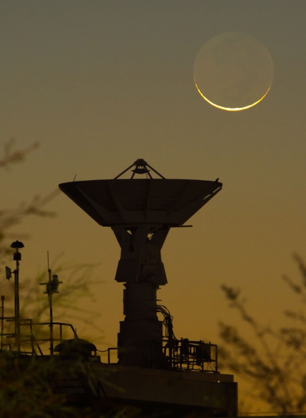 A crescent moon and NASA's Johnson Space Center’s S-band dish, atop Building 44. (Photo: NASA/Mark Sowa)