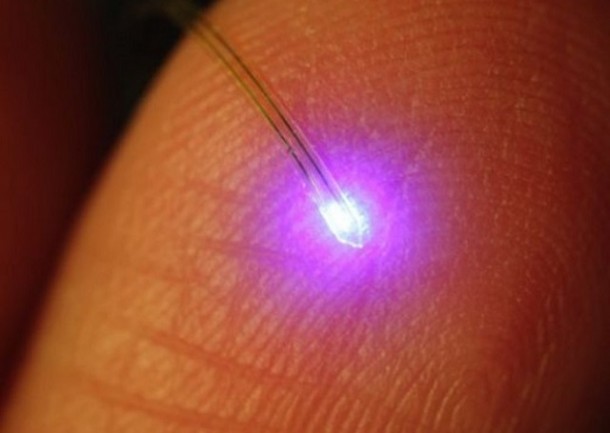 A researcher holds a ribbon of electronics including ultra-miniaturized LEDs that can be injected deep into the brain to help scientists study the mysteries of the brain.  (John A. Rogers, University of Illinois/Beckman Institute)