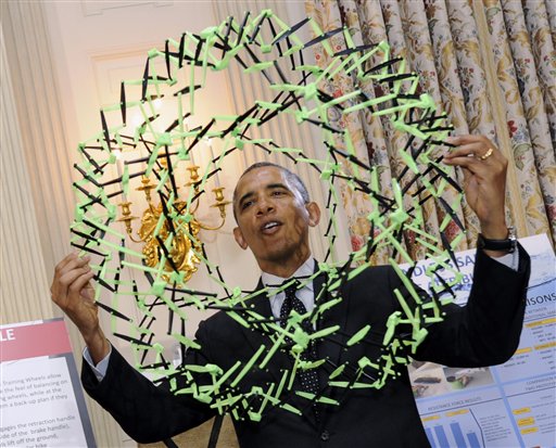 US President Barack Obama holds a model used to demonstrate how polymers expand at the 2014 White House Science Fair that was held this past week. The science fair featured the work of students from throughout the US who won science, technology, engineering and math competitions. (AP)