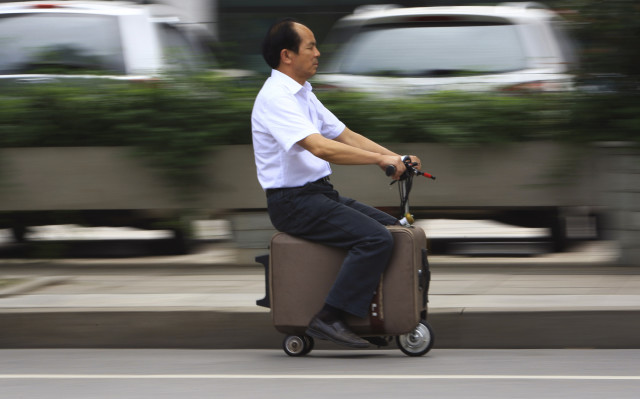 He Liang spent 10 years transforming an ordinary suitcase into an electric powered motor scooter.  He’s shown here riding his home-made suitcase-scooter down a street in Changsha, Hunan province.   He Liang says that the suitcase-scooter can zoom down the road at a top speed of up to 20km/h and one electrical charge will allow it to travel up to 50-60km. (Reuters)