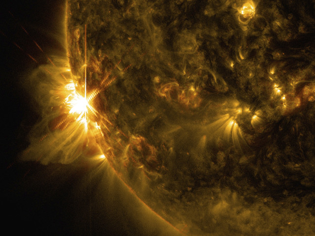 A solar flare bursts off the left limb of the sun in this image captured by NASA's Solar Dynamics Observatory on June 10, 2014. (Reuters/NASA)