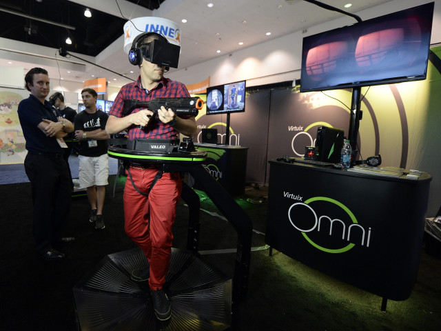 An attendee tries out the Virtuix Oculus Rift and Omni Treadmill game at the 2014 Electronic Entertainment Expo, known as E3, in Los Angeles