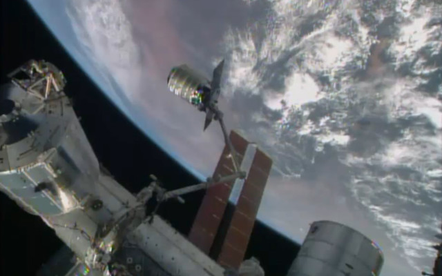 Three days after its launch here’s the Cygnus cargo spacecraft, shown here in a NASA-TV screen grab, as it’s being grasped by the ISS’ robotic arm, Canadarm on July 16, 2014.  (AP/NASA-TV)