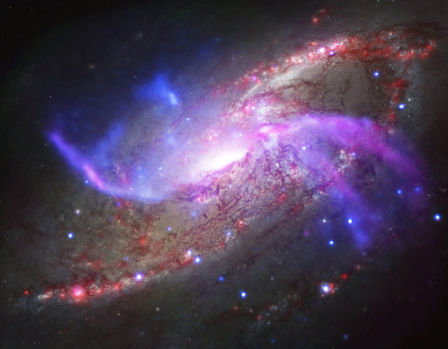 This newly released composite image is the spiral galaxy NGC 4258, which also known as M106.  The image was composed from X-ray data from NASA’s Chandra X-ray Observatory, radio data from the National Science Foundation’s Karl Jansky Very Large Array, optical data from the Hubble Space Telescope as wells as infrared data from NASA’s Spitzer Space Telescope. (NASA) 