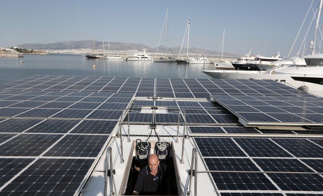 Archaeologist Julien Beck, from the University of Geneva, is shown here climbing up to the deck of the world’s largest solar-powered boat, the MS Turanor PlanetSolar, at Zea Harbor, in Athens, on Tuesday Aug. 5, 2014.  The big sun powered boat will help Beck and his colleagues with an underwater archaeology project that hopes to find traces of what could be one of the oldest human settlements in Europe. (AP)