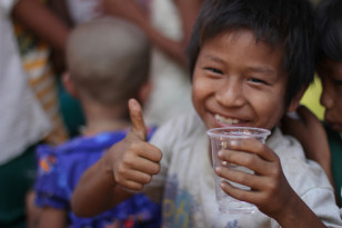 Child quenches thirst with some water (USAID)