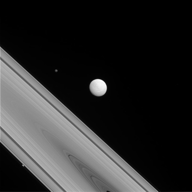 NASA’s Cassini spacecraft recently snapped this rare photo of three of Saturn's moons surrounding the planet’s ‘F-Ring’.  Each of these moons are quite different from one another. The largest of the trio Tethys, seen in the center, is round and has a variety of landscapes across its surface.  Hyperion, which can been seen to the upper-left of Tethys, is known to astronomers as the "wild one" because it has such a chaotic spin.  And then there is Prometheus, seen as the tiny dot just to the lower left of the ring.  This moon of Saturn, called a ‘Shepard satellite’, by astronomers helps keep an edge on the planet’s ‘F-Ring’. (NASA/JPL-Caltech/Space Science Institute)