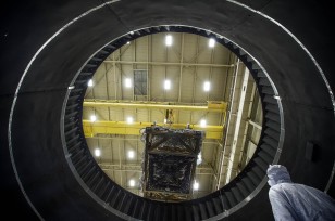 The view from inside NASA Goddard's Thermal Vacuum Chamber shows the space telescope's ISIM being lifted out by crane, after completing weeks of space environment testing. (NASA/Chris Gunn)