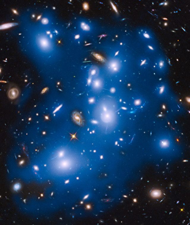 This image, released on 10/30/14, is of a massive galaxy cluster called Abell 2744, which is also nicknamed Pandora's Cluster.  Astronomers, using the Hubble Space Telescope recently found forensic evidence of galaxies torn apart long ago in this area of space. The glow comes from stars scattered into intergalactic space as a result of a galaxy's disintegration. (NASA/ESA)