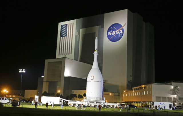 The Orion Spacecraft moves past NASA’s Vehicle Assembly Building on November 11, 2014, as it slowly makes its 22 mile journey from the Launch Abort System Facility at the Kennedy Space Center in Cape Canaveral, Fla.  Orion is scheduled to launch for a test flight on Dec. 4, 2014. (AP)