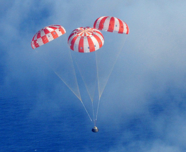 And of course what goes up must come down.  After successfully completing its first unmanned orbital test flight, NASA’s Orion Crew Module is shown here as it descends to the Pacific Ocean under its three main parachutes on 12/5/14. (AP/US Navy)