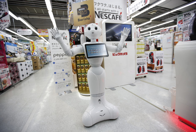 “Pepper”, a friendly human-like robot is shown here at its new job selling new Nestle coffee machines at a Tokyo electric shop on 12/1/14.  Nestle says it would like to have robots like “Pepper” working at 1,000 stores by the end of next year.  (Reuters) 