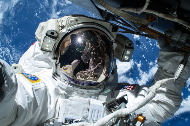 NASA astronaut Barry Wilmore is shown here working outside the International Space Station on 2/21/15.  He and fellow spacewalker Terry Virts – who can be seen reflected in Wilmore’s visor – were preparing the ISS for future arrivals by U.S. commercial crew spacecraft.  (NASA)