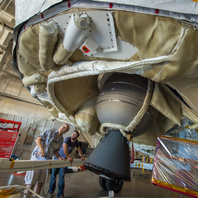 Investigators with the Low-Density Supersonic Decelerator Project (LDSD) at NASA's Jet Propulsion Laboratory are seen inspecting the LDSD spacecraft on 5/28/15.  The space vehicle that’s been dubbed the “flying saucer” is used to test new technologies that will allow the space agency to safely land heavier spacecraft such as those that would be used for future manned missions to Mars.  (NASA)