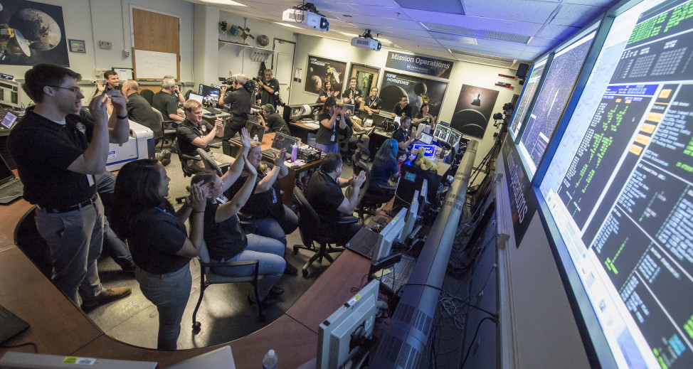 New Horizons Flight Controllers celebrate after they received confirmation from the spacecraft that it had successfully completed the flyby of Pluto, Tuesday, July 14, 2015 in the Mission Operations Center (MOC) of the Johns Hopkins University Applied Physics Laboratory (APL), Laurel, Maryland. (NASA/Bill Ingalls)