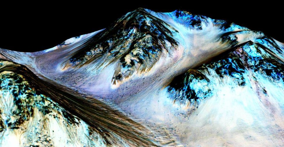 These dark, narrow, 100 meter-long streaks called recurring slope lineae flowing downhill on Mars are inferred to have been formed by contemporary flowing water. Recently, planetary scientists detected hydrated salts on these slopes at Hale crater, corroborating their original hypothesis that the streaks are indeed formed by liquid water. (NASA/JPL/University of Arizona)