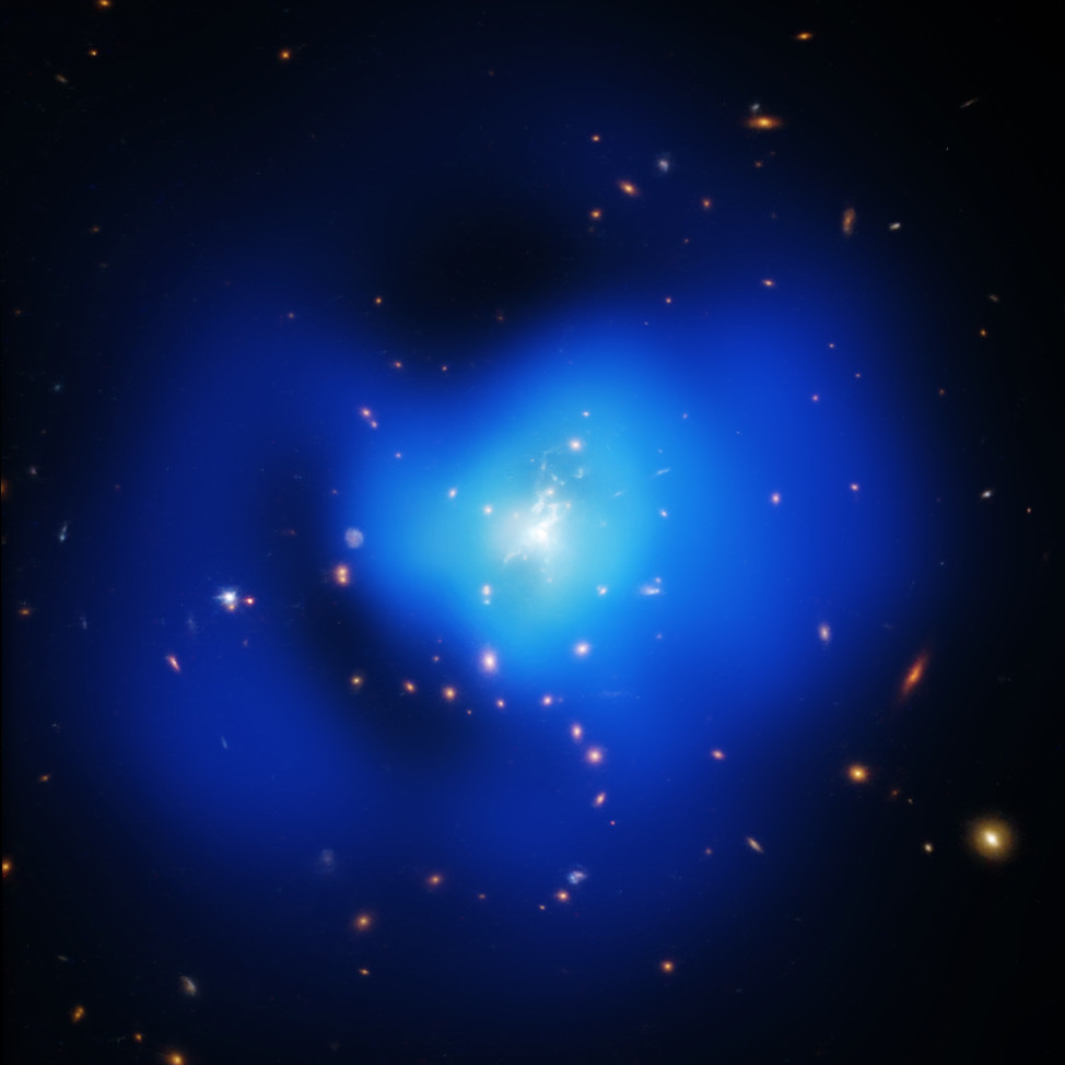 This photo of the "Phoenix Cluster", released on 9/30/15, is actually a composite of images of the galaxy cluster taken at X-ray, optical, and ultraviolet wavelengths by NASA’s Chandra X-ray Observatory, the Hubble Space Telescope, and the Clay-Magellan telescope located in Chile.  (NASA/CXC/MIT/M.McDonald et al; NASA/STScI; TIFR/GMRT)