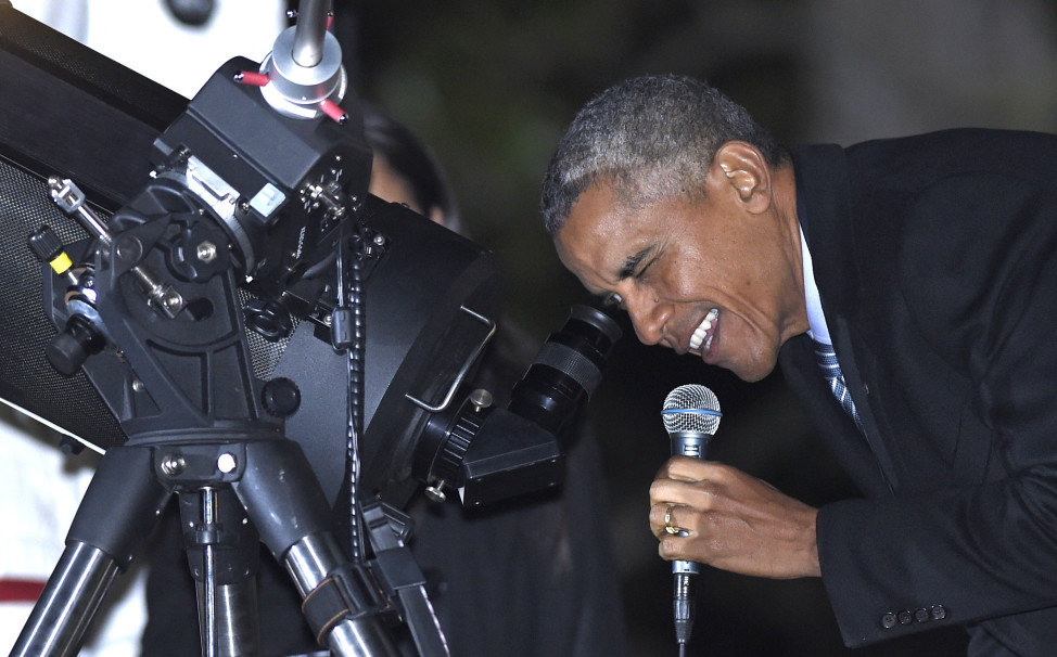 U.S. President Barack Obama takes a look at the moon through a telescope at the second White House Astronomy Night held on the South Lawn of the White House, Washington, DC on 10/19/15. The annual event brought students, teachers, astronomers, engineers, scientists, and space enthusiasts together for an evening of stargazing. (AP)