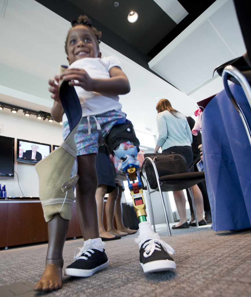 Little three year-old Miyah Williams holds her old leg prosthesis as she wears a new and more high-tech version that was attached several months earlier. Miyah was at a 10/23/15 meeting in Washington, DC that discussed problems with pediatric prosthetic devices. (AP)