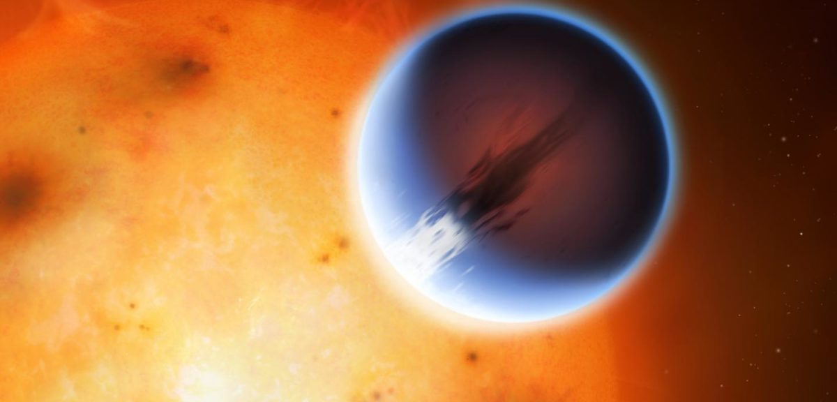 The planet HD 189733b is shown here in front of its parent star. A belt of wind around the equator of the planet travels at At nearly 8,700 kilometers per hour from its day side to the night side. The day side of the planet appears blue due to scattering of light from silicate haze in the atmosphere. The night side of the planet glows a deep red due to its high temperature. (Mark A. Garlick/University of Warwick)
