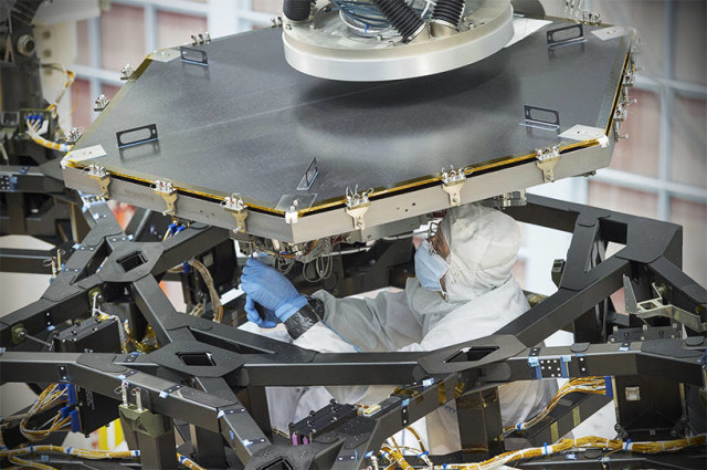An engineer at NASA's Goddard Space Flight Center worked to install the first flight mirror onto the telescope structure at NASA's Goddard Space Flight Center in Greenbelt, Maryland. (NASA/Chris Gunn)