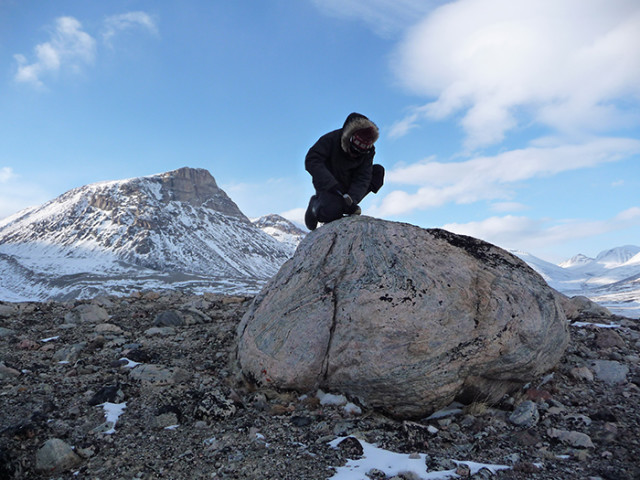 Geologist Jason Briner, from the University at Buffalo  samples a boulder left by a glacier on Baffin Island, around the time of early Viking settlement. Measurements of chemical isotopes within the rock suggest settlers in neighboring Greenland faced cold weather. (Nicolás Young)