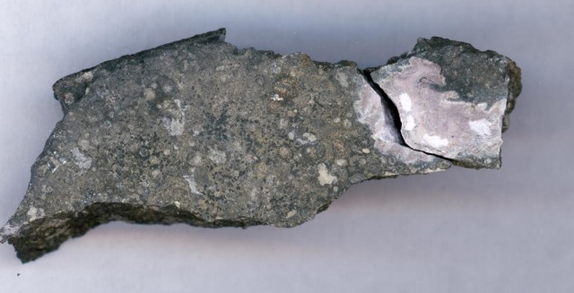 This close-up picture shows a ceramic-like refractory inclusion (pink inclusion) still embedded into the meteorite in which it was found. (Origins Lab, University of Chicago)