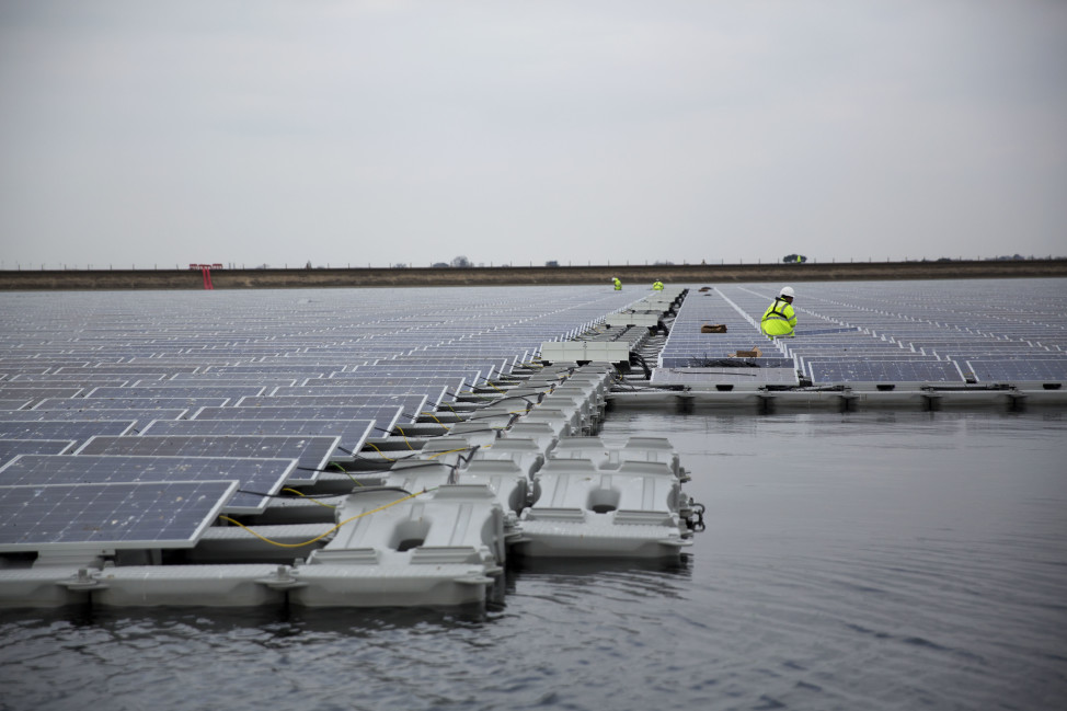Contractors are seen working on a nearly completed floating solar panel array on the Queen Elizabeth II Reservoir near Walton-on-Thames in south west London, Monday, March 21, 2016. The floating array will consist of just over 23,000 solar photo-voltaic panels and within its first year will generate an estimated 5.8 million kilowatt hours of electricity. The arrays will help produce power on both cloudy and sunny days. (AP)