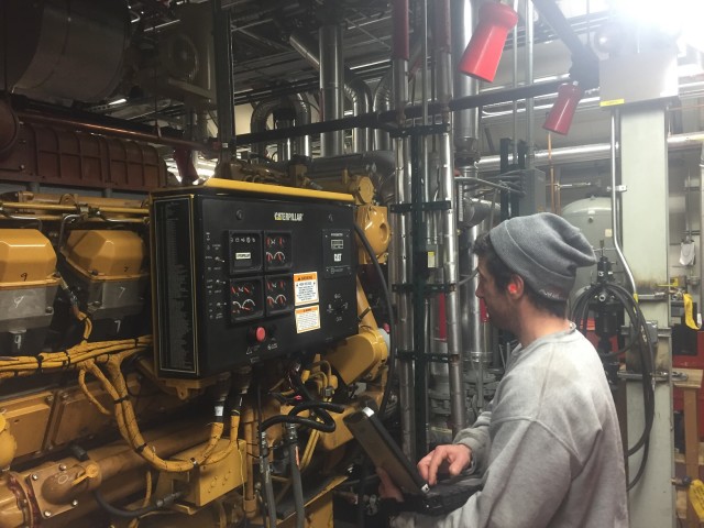 Rounds are conducted every two hours to ensure the power plant equipment is running properly. "Rosie" the foreman inspects a generator. (Photo by Refael Klein) 