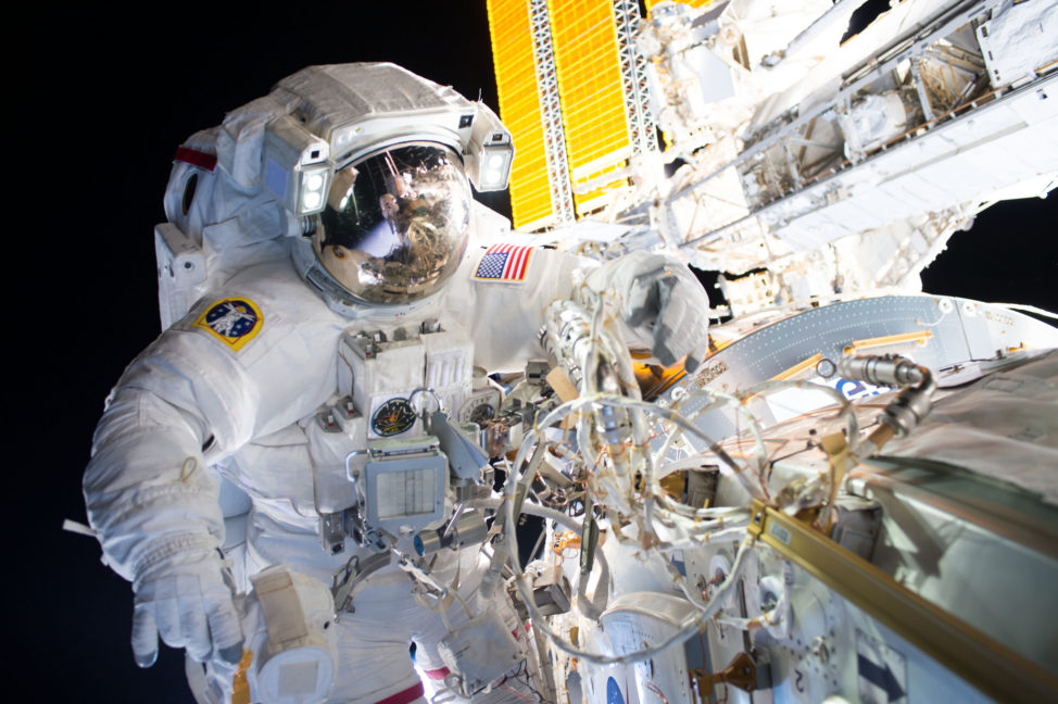 NASA astronauts Jeff Williams, who is shown here, along with crewmate Kate Rubins (who can be seen reflected in William’s visor) successfully installed a new international docking adapter 8/19/16 during a five hour and 58-minute spacewalk. (NASA)