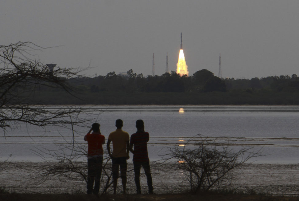 People watch as Indian Space Research Organization (ISRO)'s Polar Satellite Launch Vehicle carrying the 712 kg Cartosat-2 Series Satellite along with 30 co-passenger satellites, blasts off from the Satish Dhawan Space Centre at Sriharikota in Andhra Pradesh, around 117 kilometers (72 miles) northeast of Chennai, India, Friday, June 23, 2017. (AP)