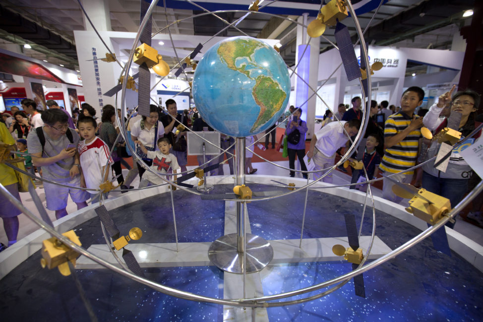 People visiting the China Beijing International High-Tech Expo in Beijing, Saturday, June 10, 2017 are seen here looking at a mockup of China's homegrown Beidou satellite navigation system. (AP)