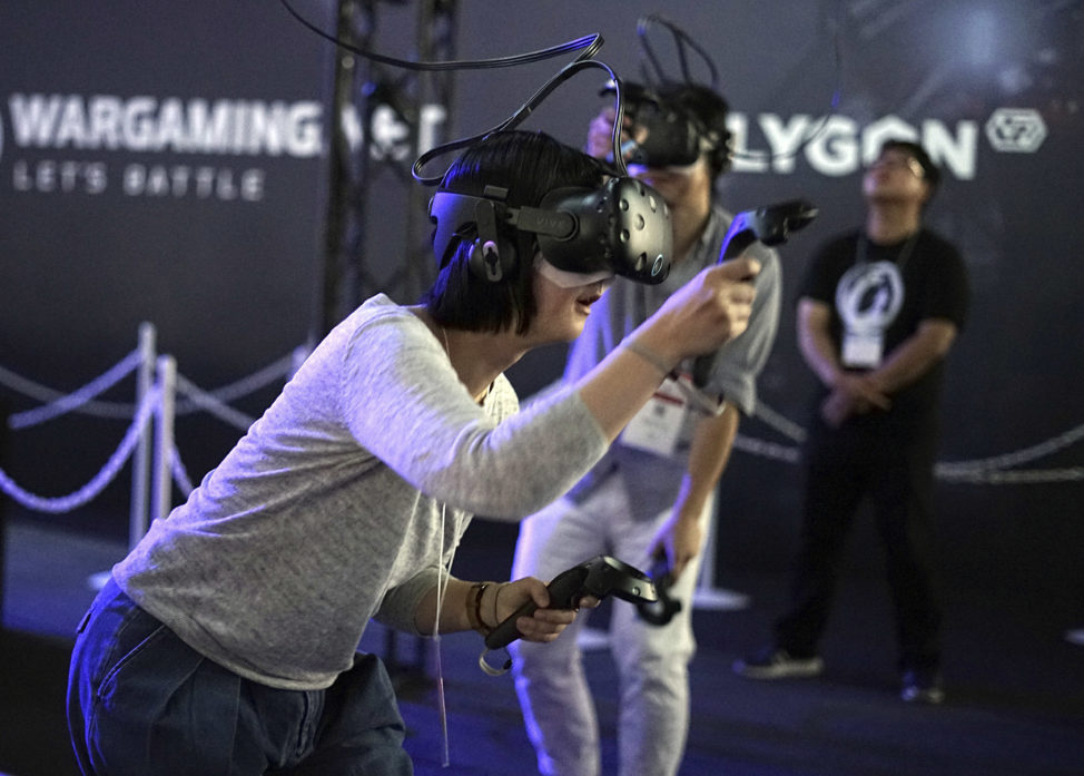 Visitors to the Tokyo Game Show, try out a game with a virtual reality headset in this photo taken on September 21st. The exhibition ran from September 21st through September 24th. (AP Photo/Eugene Hoshiko)