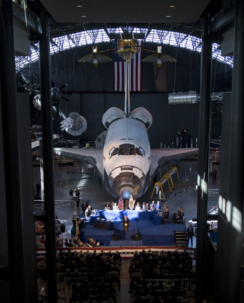 With NASA’s Space shuttle Discovery as a backdrop, U.S. Vice President Mike Pence delivers his opening remarks during the National Space Council's first meeting, 10/05/17 at the Smithsonian National Air and Space Museum's Steven F. Udvar-Hazy Center in Chantilly, Va. (NASA/Joel Kowsky)