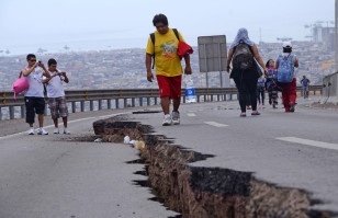 People walk along a cracked road in Iquique, northern Chile, on April 2, 2014. (AFP)