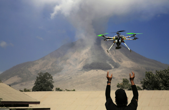 An official of the Center for Research and Technology Volcanoes Development (BPPTK) releases a drone quadcopter to monitor activity from the Mount Sinabung volcano in Sumatra, Indonesia (Reuters)