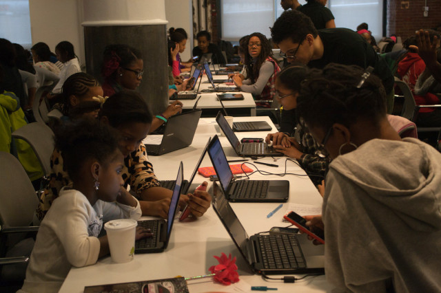 Volunteer teachers work help young students with computer programming at a Black Girls Code class in New York. (Black Girls Code)